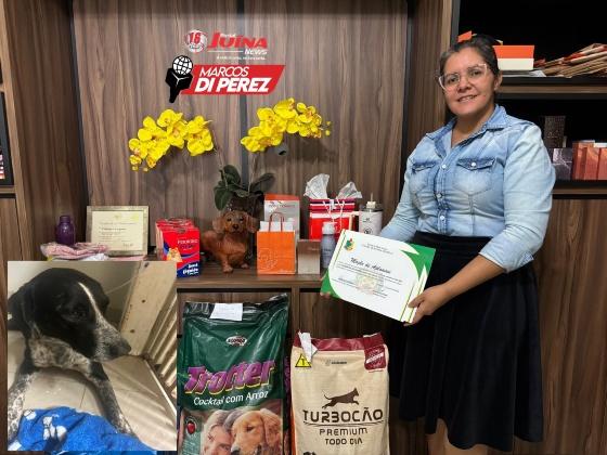 Cristiane segura com orgulho moção de aplausos que a associação recebeu da câmara de vereadores de Juína